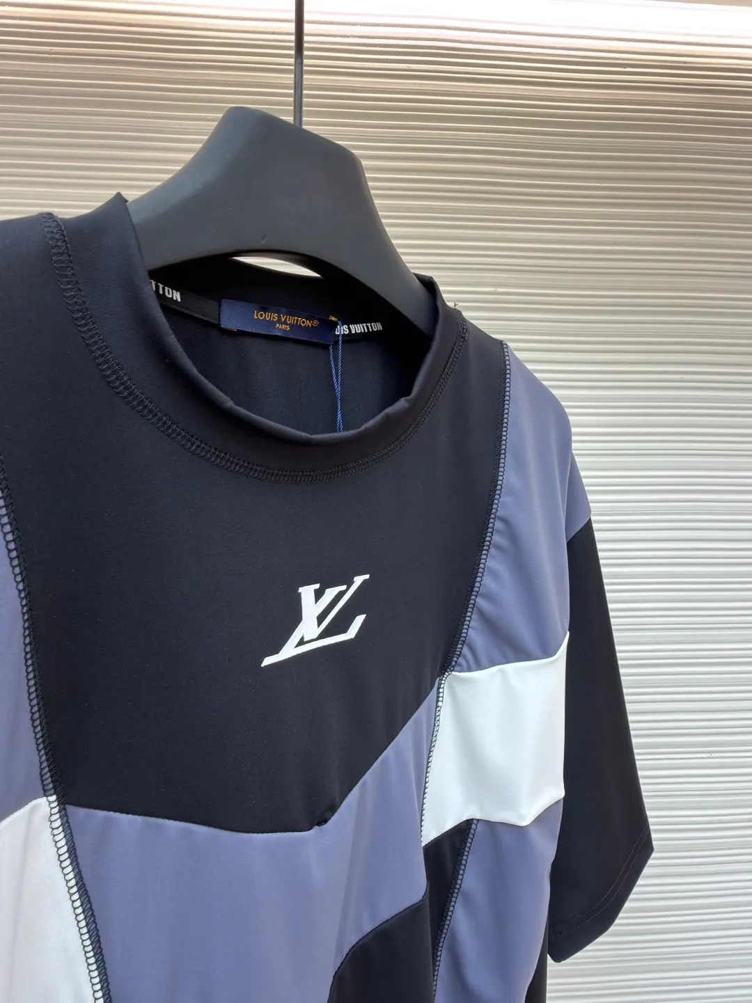 LOUIS VUITTON Spliced round neck jogging short-sleeved T-shirt ●Original version: purchased and developed by 8167 ●Item number: 1682020-A20 ●Fabric: cotton fabric ●Technology: made on positioning cutting machine ●Color: black, gray and white ●Type: fitted version ●Weight: about 295 grams ●Size: S-M-L-XL ●Description: This LOUIS VUITTON The FW25 jogging short-sleeved T-shirt is made of high-elastic technical knitted fabric (presumably a blend of polyester fiber and spandex). It has been treated with directional stretching technology and has both breathability and sports extensibility. The body of the garment adopts color-blocking insert technology: black, gray, and white panels are spliced ​​diagonally in a V-shape, and the edges are processed with "boneless overlocking" to make the seams smooth and smooth. The "LV" logo on the chest uses a silicone embossing + embroidery composite process: first outline the outline with embroidery thread of the same color, and then cover it with a matte silicone layer, which not only ensures the three-dimensionality of the logo, but also prevents it from falling off after washing. The neckline is double-layered ribbed and has built-in elastic webbing for reinforcement, making it less likely to deform after long-term wear. The overall shape is sporty and slim-fitting, and the arc of the cut piece has been ergonomically optimized, making it suitable for light sports such as jogging. The overall wiring is straight and delicate, the fabric is comfortable and soft, and the color is consistent without color difference. It can be matched with the same style to create a fashionable look and control various occasions. Customized accessories, complete with three standards, same style for men and women!